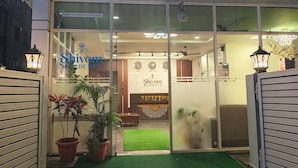The Shivom Residency Luxury Boutique Hotel entrance with a reception area, potted plants, and a green mat. - SHIVOM RESIDENCY (Hyderabad)