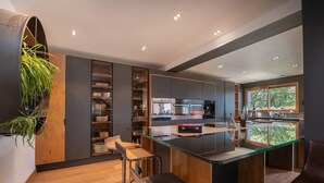 Une cuisine moderne dotée d’un îlot central, de tabourets de bar et d’une grande fenêtre.