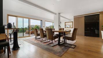 Un comedor espacioso con una mesa grande y sillas, ventanas amplias y vistas al exterior.