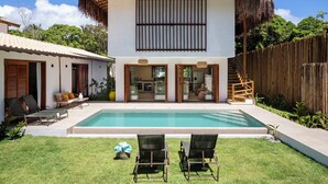 A modern house with a swimming pool, a covered patio, and a wooden fence. - Casa Limone (Porto Seguro)