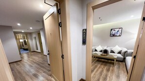 Una habitación de hotel moderna con piso de madera, un sofá y una pequeña mesa.