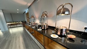 Una cocina moderna con una encimera larga, electrodomésticos de acero inoxidable e iluminación colgante.