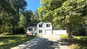 Une maison à deux étages avec un garage à l’avant et une véranda couverte.