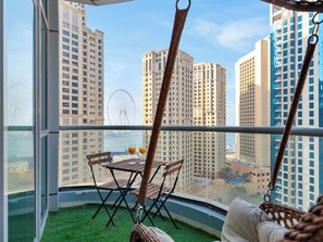 A balcony with a view of tall buildings and a Ferris wheel. - Luxury Waterfront View with Ain Dubai  (Dubai)