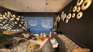 A modern interior with a staircase, seating area, and decorative wall art. - Acqua Novotel Suites w/ Rockwell View (Mandaluyong City)