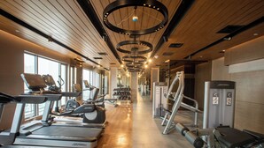 Ein Fitnessstudio mit Laufbändern, Crosstrainern und Gewichtstrainern.