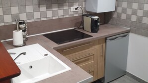 A modern kitchen with a sink, stove, and dishwasher. - Gite des 3 têtes de loups (Fumay)