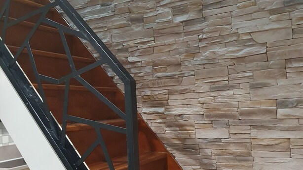 A staircase with a stone wall backdrop. - Gite des 3 têtes de loups (Fumay)