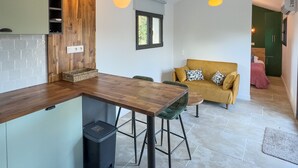 Uma cozinha moderna com bancada de madeira, mesa de jantar com cadeiras e luminárias pendentes.