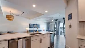 Une cuisine moderne dotée d’un îlot central, d’un coin repas avec vue et d’un ventilateur de plafond.