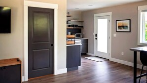 A modern kitchen with dark cabinetry, a microwave, and a coffee maker on the countertop. - Cozy modern studio apartment in quiet Ridgefield with AC (Ridgefield)