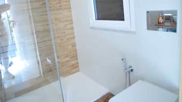 Een douche, een haardroger, een bidet, handdoeken