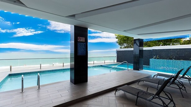 An indoor swimming pool with a view of the beach, lounge chairs, and a glass railing. - Playa Farallon, BEACHFRONT, 3-bedroom WITH 3 ensuite condo. OCEAN VIEW BALCONY (Río Hato)