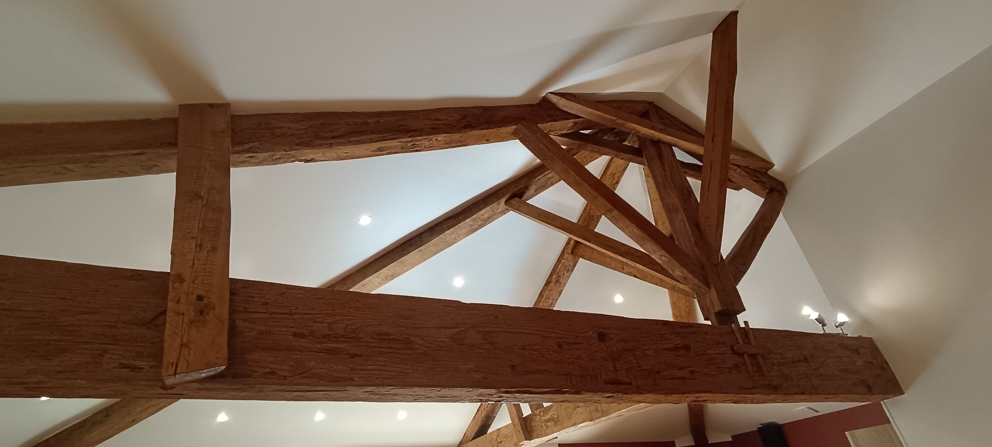 A wooden ceiling structure with visible beams and recessed lighting.