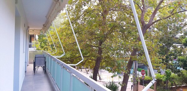 A balcony with a view of trees and a stop sign.