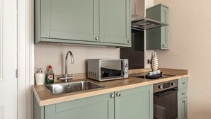 Une cuisine équipée d’un évier, d’un four à micro-ondes et d’une cuisinière.
