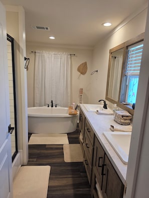 A modern bathroom with a freestanding bathtub, a double sink vanity, and a large mirror. - Midlake. Conveniently located close to Toledo Town. Pet friendly. (Many)