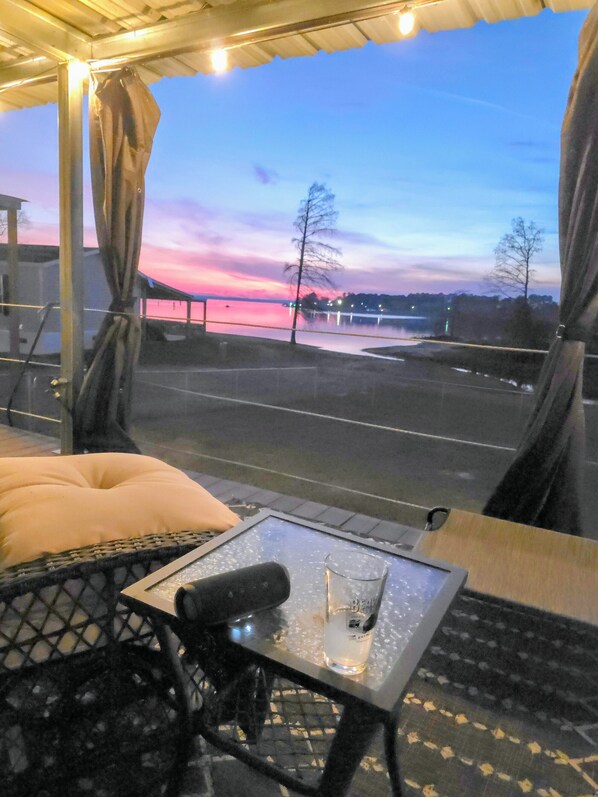 A terrace with a glass table, a cushion, and a bottle of Barley. - Midlake. Conveniently located close to Toledo Town. Pet friendly. (Many)