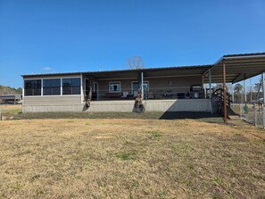 A single-story building with a covered patio area, a fenced yard, and a clear blue sky. - Midlake. Conveniently located close to Toledo Town. Pet friendly. (Many)