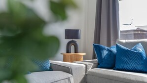 A modern living room with a sofa, a side table, and a lamp.