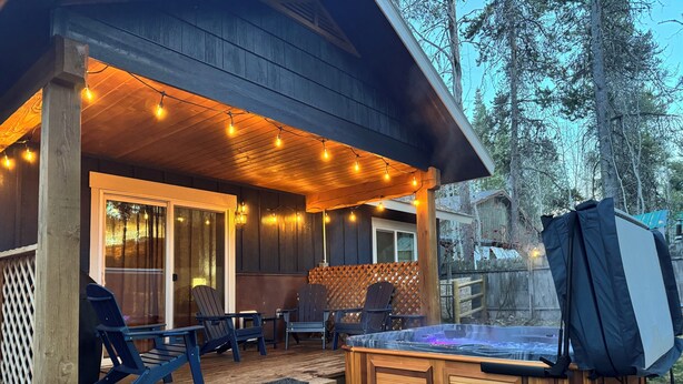 Una terraza de madera con mobiliario exterior y un jacuzzi.
