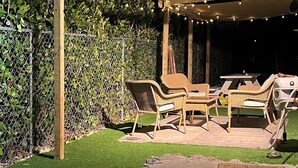 An outdoor patio with wicker furniture, a table, and a canopy. - Delightful 2 bedroom - Island Cottage (Key Largo)