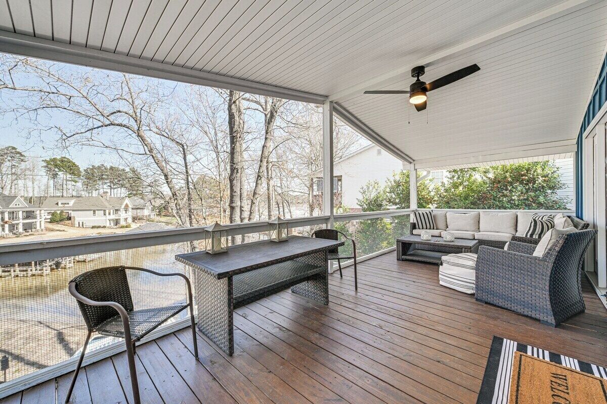 Une terrasse couverte avec une table et des chaises, un canapé et un ventilateur de plafond.