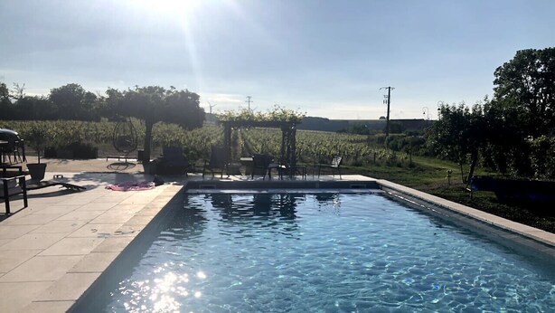 Una piscina rectangular con agua cristalina, rodeada por un borde de baldosas.
