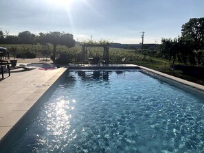 Una piscina rectangular con agua cristalina, rodeada por un borde de baldosas.