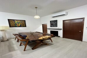 A dining area with a wooden table and chairs, a pendant light, and artwork on the walls. - Spacious apartment for 8 in Zona Americana, All Nearby. (Guadalajara)