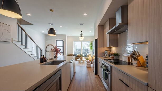 Una cocina moderna con una isla central, armarios de madera y horno empotrado.
