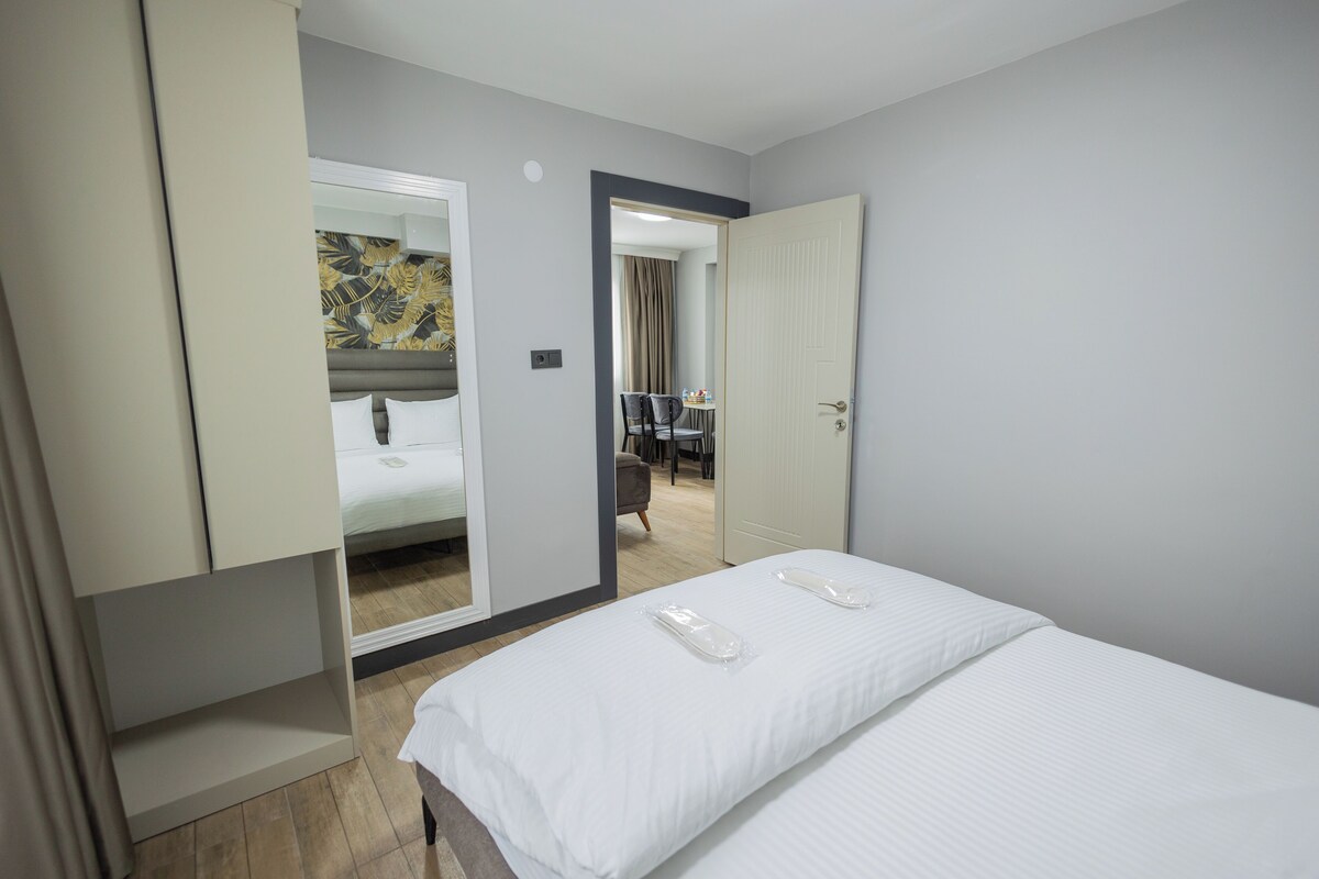 Una habitación de hotel con cama, un armario y una puerta que da a un comedor.