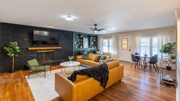 Un salon moderne avec une cheminée, un canapé, une table basse et un coin repas comprenant des chaises et une table.