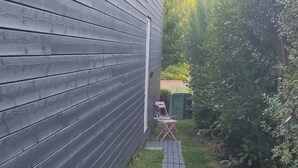 A narrow pathway leading to a building with a dark exterior. - Fully-equipped 1 room furnished studio without partitions (Chavagnes-en-Paillers)