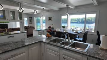 A modern kitchen with granite countertops, stainless steel appliances, and a view of a lake.