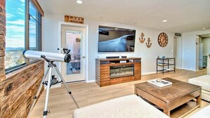 Una sala de estar con un telescopio, un televisor y un letrero que dice "LAKE".