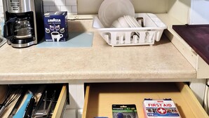 A kitchen with a coffee maker, dish rack, and various kitchen items. - Charming 3-bedroom house in peaceful Binghamton, close to downtown, with ACs (Binghamton)