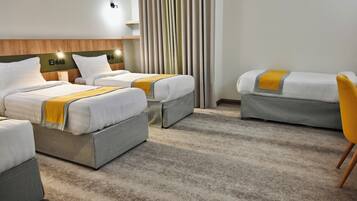 Habitación cuádruple, vistas a la ciudad | Caja fuerte, escritorio, cortinas opacas y tabla de planchar con plancha