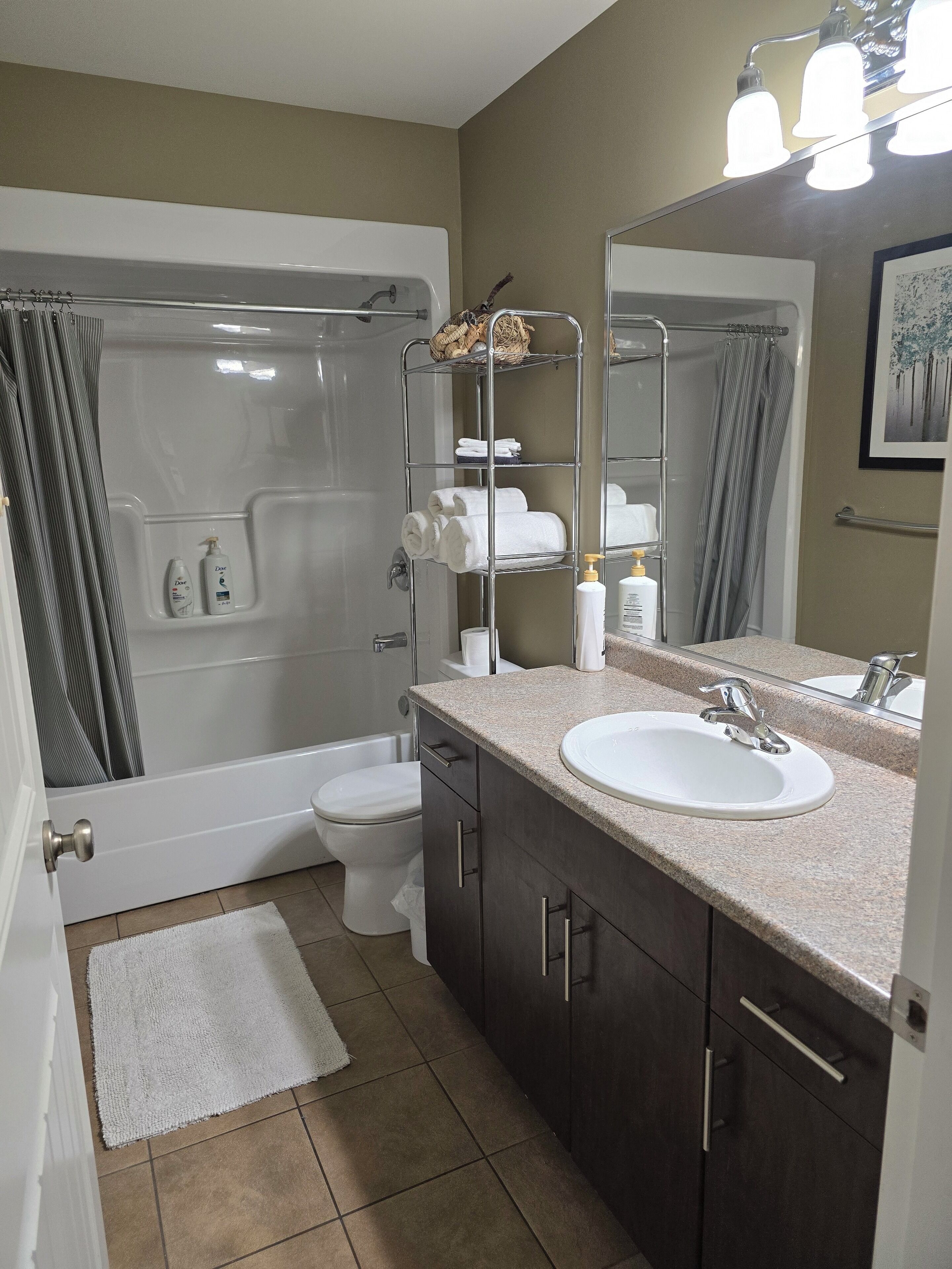 Une salle de bain moderne équipée d’une baignoire, de toilettes et d’un lavabo.