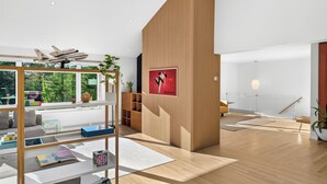 A modern interior with a wooden accent wall, a space shuttle model, and a poster. - Dartmouth Graduation—Luxury MCM Home in Hanover (Hanover)