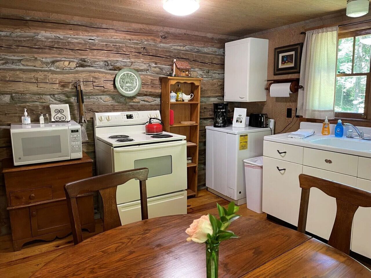 Une cuisine rustique avec des murs en bois, une table à manger en bois et des appareils électroménagers simples.