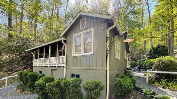 A rustic cabin with a porch, surrounded by dense forest. - Private fire pit, creek: Bryson city (Bryson City)
