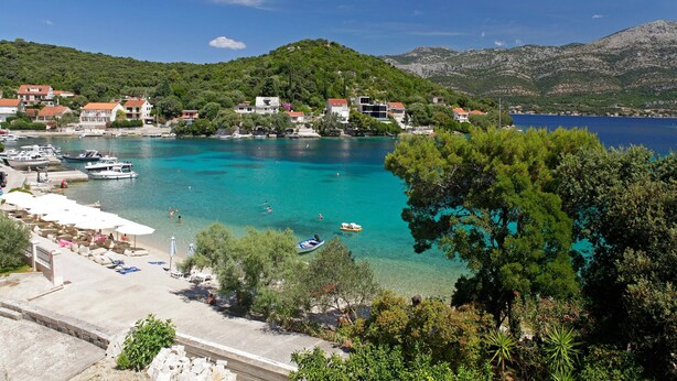 A coastal town with clear turquoise waters, boats, and a marina. - Beachfront Orange Apartment (Žrnovo)