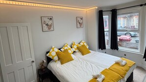 A hotel room with a large bed, white walls, and a window with curtains. - Amazing Garden Apartment - Miami Lodge (Reading)