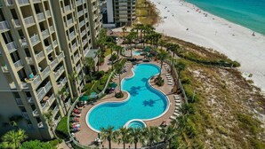 Un hôtel de grande hauteur doté d’une grande piscine et d’une plage.