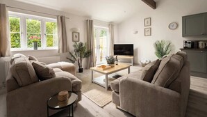 Amplia sala de estar con un conjunto de sofá, una mesa de centro y un televisor.