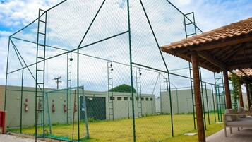 A fenced sports facility with a covered seating area.