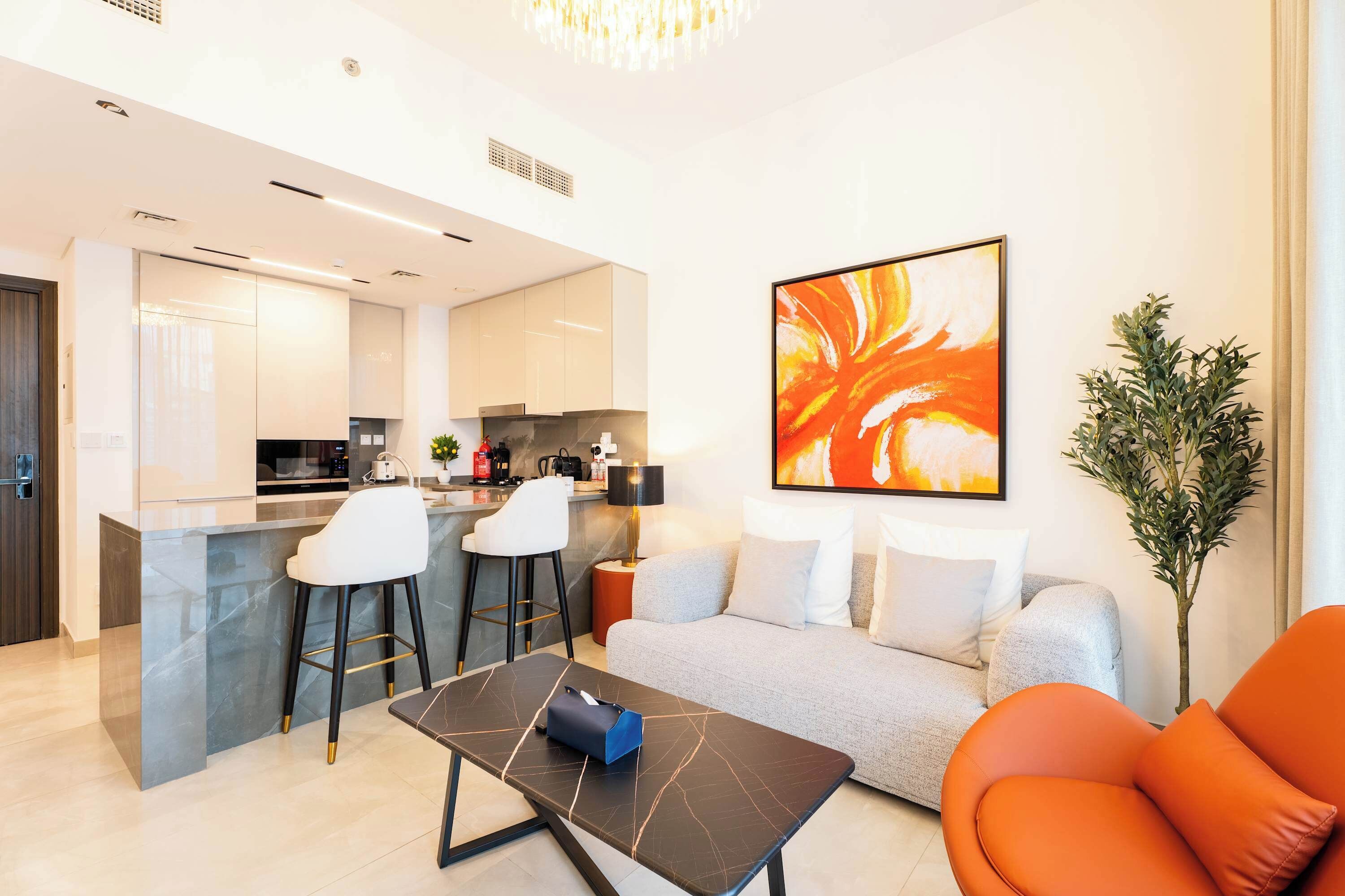 Una sala de estar moderna con un sofá, una mesa de centro y una zona de bar con taburetes.