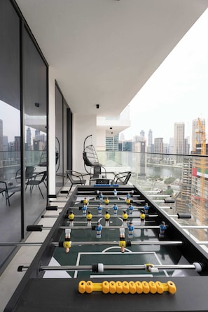 Ein Tischkicker auf einem Balkon mit Blick auf die Stadt.
