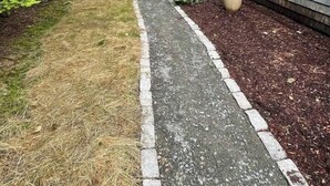 A pathway leading to a house with a grey exterior and a small garden area. - Acadia Coastal Cape 20 min to Acadia National Park (Lamoine)